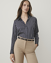 A woman in a striped blouse and tan pants stands against a plain background. carousel Product Image 1
