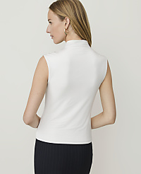 A woman in a white sleeveless turtleneck and a dark pinstripe skirt stands against a plain white background. carousel Product Image 4