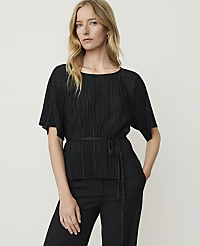 A blonde woman in a black pleated top and pants stands against a plain white background. carousel Product Image 1