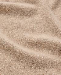 A close-up view of soft, beige fabric with gentle folds fills the frame, creating a textured and warm background. carousel Product Image 2