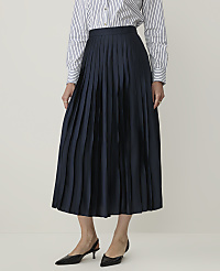 A person in a striped shirt and navy pleated skirt stands against a plain, light background. carousel Product Image 2