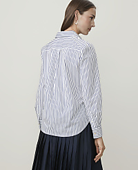 A woman in a striped shirt and pleated skirt stands against a plain background. carousel Product Image 2