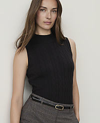 A woman in a black cable-knit sleeveless turtleneck and plaid pants stands against a plain white background. carousel Product Image 1