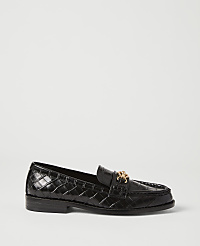 A black, crocodile-embossed loafer with a gold buckle sits on a plain white background. carousel Product Image 1
