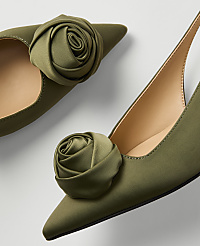 Two olive green satin pointed-toe heels with fabric rose embellishments are displayed against a plain white background. carousel Product Image 2