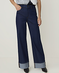 A person stands in dark wash wide-leg jeans with cuffed hems against a plain white background. carousel Product Image 2