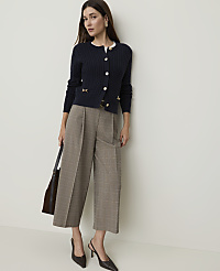 A woman in a navy cardigan and plaid culottes stands against a plain white background, holding a dark tote bag. carousel Product Image 2