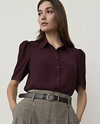A woman in a burgundy blouse and plaid pants stands against a plain background. carousel Product Image 1