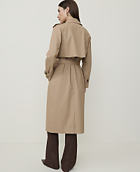 A woman in a tan trench coat and brown pants stands against a plain, light background. carousel Product Image 2