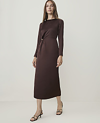 A woman in a long-sleeved brown dress stands against a plain, light-colored background. carousel Product Image 1