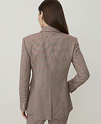 A woman in a brown and red checkered blazer stands against a plain white background. carousel Product Image 2