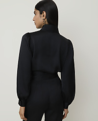 A woman in a black satin blouse with puffed sleeves and high-waisted pants stands against a plain white background. carousel Product Image 2
