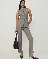 A woman in a plaid vest and pants stands with a handbag, against a plain white background. carousel Product Image 1