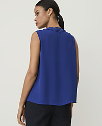 A woman in a blue sleeveless top and pinstripe pants stands against a plain white background. carousel Product Image 2