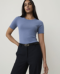 A woman in a blue t-shirt and pinstripe pants stands against a plain, light gray background. carousel Product Image 1