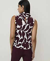 A woman in a floral sleeveless top and maroon pants stands against a plain white background. carousel Product Image 2