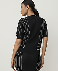 A woman in a black top with white pinstripes stands against a plain white background. carousel Product Image 2