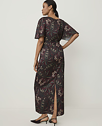 A woman in a patterned dress stands against a plain background. carousel Product Image 2