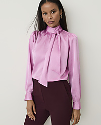 A woman in a pink satin blouse and burgundy pants stands against a plain white background. carousel Product Image 1