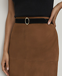 A person's torso is adorned with a brown suede skirt and a black velvet belt with a gold buckle, set against a plain, light-colored background. carousel Product Image 4