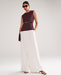 A woman in a maroon plaid top and white wide-leg pants stands against a plain, light gray background. carousel Product Image 6