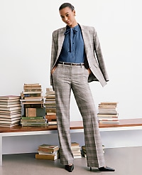 A woman in a plaid suit stands in front of a wall of books. carousel Product Image 4