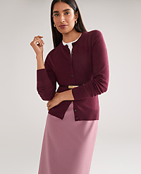 A woman in a burgundy cardigan and pink skirt stands against a plain gray background. carousel Product Image 2