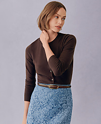 A woman in a brown cardigan and blue lace skirt stands against a plain purple background. carousel Product Image 3
