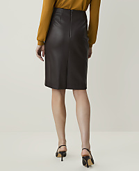 A woman in a brown leather skirt and mustard-colored top stands against a plain, light background. carousel Product Image 3