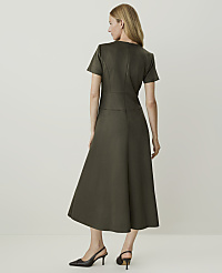 A woman in a dark green dress stands against a plain, light background. carousel Product Image 2