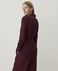 A woman in a burgundy blouse and pants stands against a plain, light-colored background. carousel Product Image 2