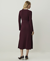 A woman in a burgundy ribbed midi dress and heels stands against a plain, light-colored background. carousel Product Image 2