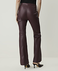 A person wearing burgundy faux leather flare pants and black heels stands against a plain white background. carousel Product Image 3