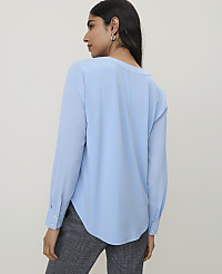 A woman in a light blue blouse and patterned pants stands against a plain, light gray background. carousel Product Image 2