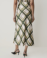 A person wearing a cream-colored skirt with a green diamond pattern and black heels stands against a plain white background. carousel Product Image 3