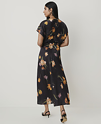 A woman in a black floral dress stands against a plain white background. carousel Product Image 2