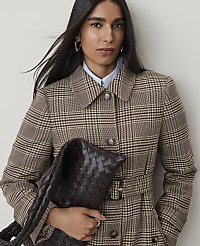 A woman in a plaid coat holds a woven bag in front of a plain background. carousel Product Image 3