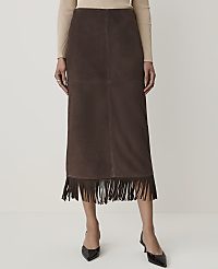 A person models a brown suede skirt with fringe detailing in the foreground, against a plain white background. carousel Product Image 2