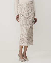 A woman models a cream-colored, floral-embroidered pencil skirt and matching heels against a plain white background. carousel Product Image 2