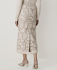 A woman in a cream sweater and a cream embroidered skirt with floral cutouts stands against a plain cream background. carousel Product Image 3