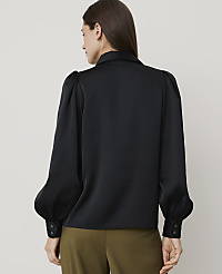 A woman in a black satin blouse with puffed sleeves stands against a plain white background. carousel Product Image 2