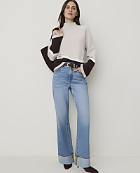 A woman in a cream and brown sweater and cuffed jeans stands against a plain white background. carousel Product Image 3