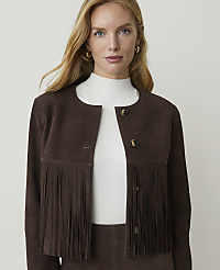 A woman with blonde hair and blue eyes, wearing a brown suede jacket with fringe, stands against a plain white background. carousel Product Image 5