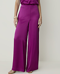 A person wearing wide-leg magenta satin pants and gold sandals stands against a plain, light-colored background. carousel Product Image 2