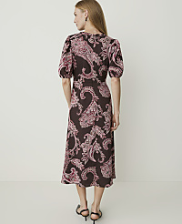 A woman in a brown paisley dress stands against a plain white background. carousel Product Image 2