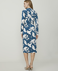 A woman in a teal floral dress stands against a plain, light gray background. carousel Product Image 2
