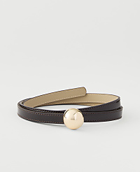 A thin, dark brown leather belt with a gold sphere buckle is coiled on a plain white background. carousel Product Image 1