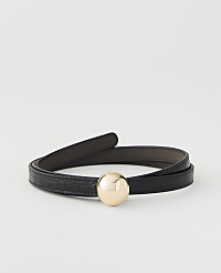 A black, textured belt with a gold sphere buckle is coiled on a plain white background. carousel Product Image 1