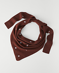 A rust-colored knitted scarf with small white embroidered leaves is laid out on a plain white background. carousel Product Image 1