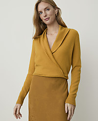 A woman in a mustard yellow wrap sweater and brown skirt stands against a plain, light background. carousel Product Image 1